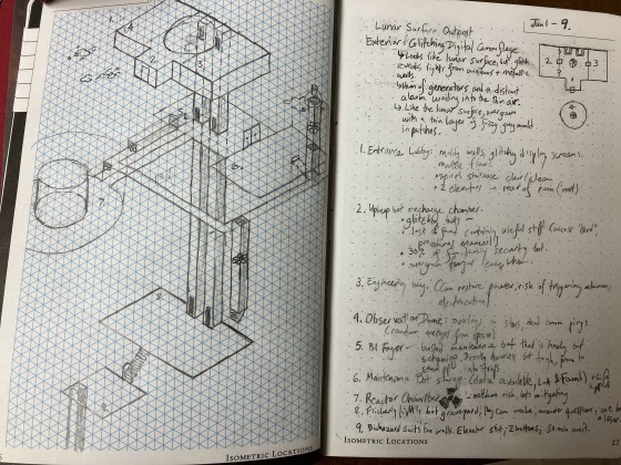 A photo of an open notebook with scrawlings and a hand-drawn isometric map.