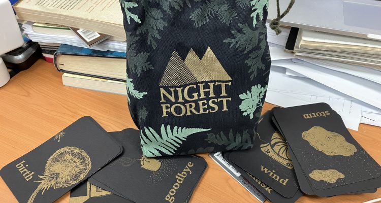 Night Forest game image with cards spread out by the game bag.